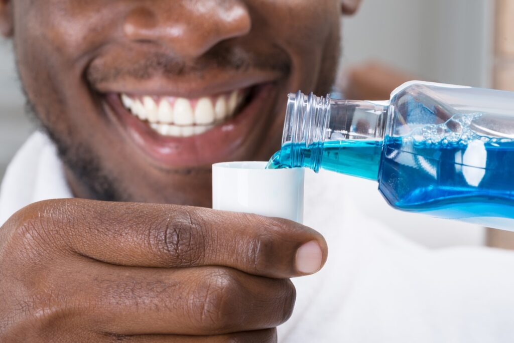 Man using mouthwash to maintain healthy gums