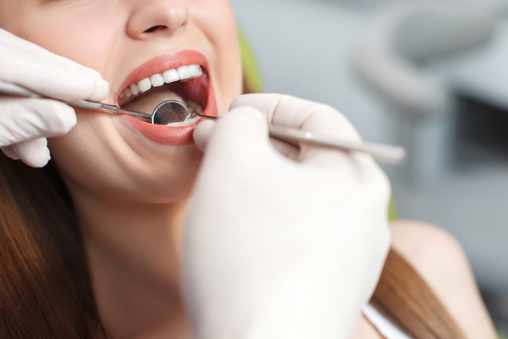 Dentist cleaning young woman's teeth