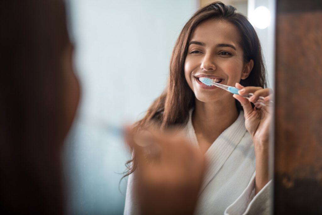 Woman brushing her teeth and maintaining good oral hygiene