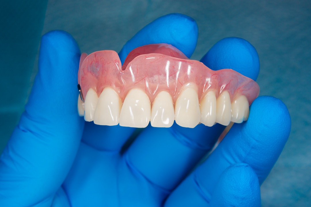 Dentist holding complete upper denture