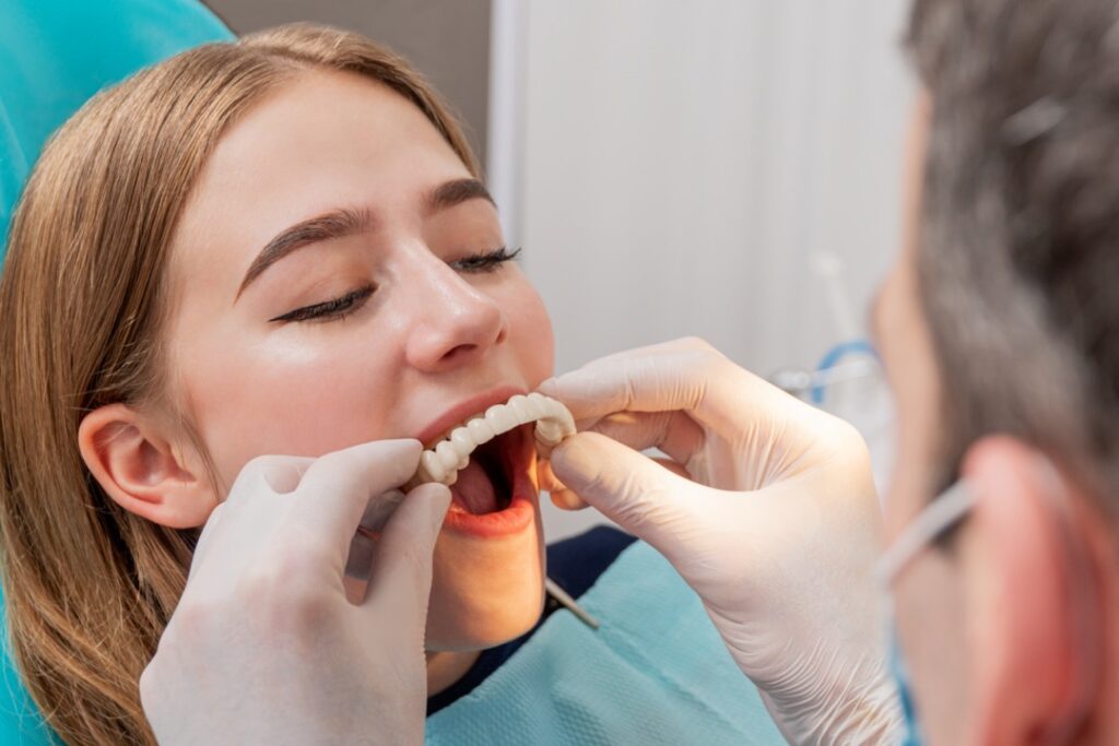 Dentist fitting dentures on patient