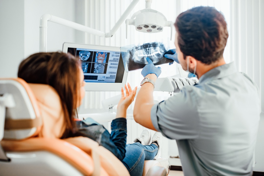 Dentist reviewing dental x-rays with patient